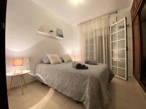 1 dormitorio con 1 cama y 1 mesa con lámpara en Apartamento Felipe Neri 10, en Málaga