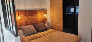 Cama pequeña en habitación con cabecero de madera en Le Pamaro en La Chapelle-dʼAurec