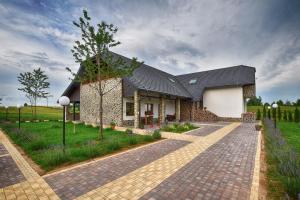 a house with a black roof and a brick driveway at Villa Stone 1 in Rakovica