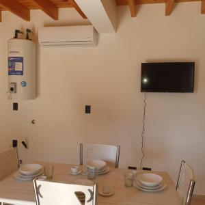 uma sala de jantar com uma mesa e uma televisão na parede em pedro de valdivia 219 em San Juan