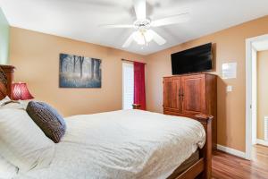 Un dormitorio con una cama y un televisor de pantalla plana. en Jan's Riverside Retreat, en Pigeon Forge