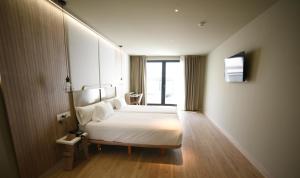 um quarto de hotel com uma cama e uma janela em IMI Hotel & Spa em Ourense