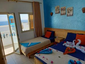 um quarto com 2 camas e uma varanda em Dahab Beach Lodge em Dahab