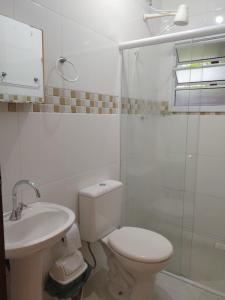 uma casa de banho com um WC, um lavatório e um chuveiro em Quitinetes Canto Verde Caraguá em Caraguatatuba