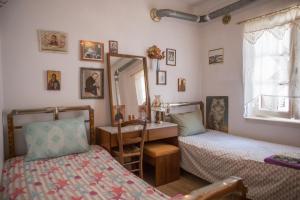 a bedroom with two beds and a desk and a mirror at Traditional House at Central Square in Zagora