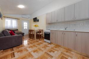 kuchnia i salon z kanapą i stołem w obiekcie APARTMANI ZLATA w mieście Vir +6 zdjęć