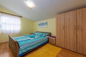 sypialnia z łóżkiem i dużą drewnianą szafką w obiekcie APARTMANI ZLATA w mieście Vir