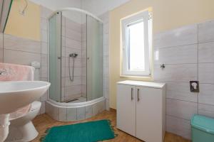 łazienka z wanną, umywalką i prysznicem w obiekcie APARTMANI ZLATA w mieście Vir