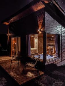 a cabin with a large glass window on a deck at Cabanas Invernada de Cima in São Joaquim