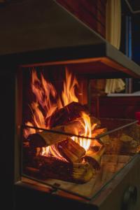 una estufa con fuego y comida. en Cabanas Invernada de Cima, en São Joaquim