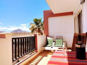 uma varanda com mesa e cadeiras e vista para o deserto em Sunset House et piscine em Parque Holandes