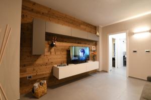 un salon avec une télévision sur un mur en bois dans l'établissement La Maison de Ginny, à Villefranche