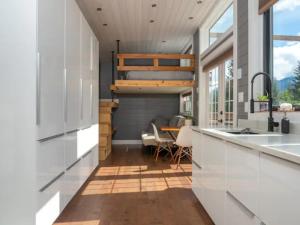 a kitchen with white cabinets and a sink and a table at Golden Tiny Homes in Golden