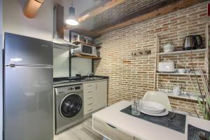a kitchen with a refrigerator and a washer and dryer at AP Plaza de España 5 in Madrid