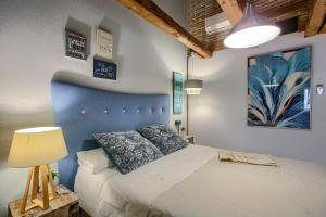a bedroom with a large bed with a blue headboard at AP Plaza de España 5 in Madrid