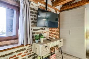 a living room with a television on a brick wall at AP Plaza de España 5 in Madrid