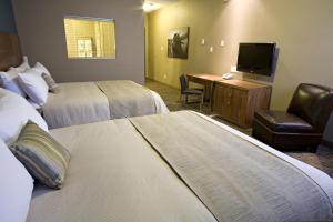 a hotel room with two beds and a television at Heritage Inn Hotel & Convention Centre - Pincher Creek in Pincher Creek