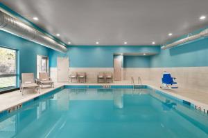 una piscina con paredes y sillas azules en Holiday Inn Express & Suites Salisbury, an IHG Hotel, en Salisbury
