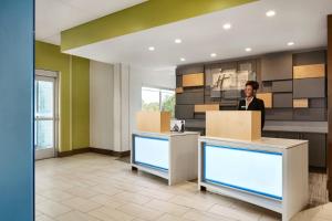 Un hombre de pie en un mostrador en un vestíbulo. en Holiday Inn Express & Suites Salisbury by IHG, en Salisbury