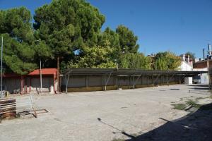 a parking lot with a building with a canopy at Hostal La Reserva in Cobeña