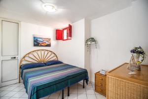 a bedroom with a bed and a wooden dresser at Emerald Holiday House in Marina di Mancaversa