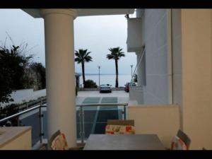 薩蘭達的住宿－Beachfront Sion Sarande Apartment 1，阳台配有桌椅,享有风景。