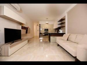 a living room with a white couch and a kitchen at Beachfront Sion Sarande Apartment 1 in Sarandë