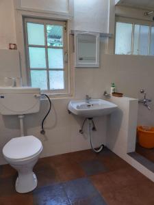 La salle de bains est pourvue de toilettes et d'un lavabo. dans l'établissement Casa Encanto Homestay, à Shillong