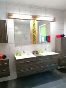 een badkamer met 2 wastafels en een grote spiegel bij Apart JOVE-Ötz in Oetz +5 foto's