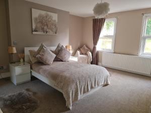 a bedroom with a bed and two chairs in it at Rainworth Lodge in Nottingham