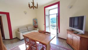 a living room with a table and a tv at Ca Giulietto Antico Casale in Lunigiana in Pontremoli