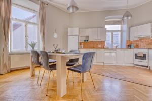 Historic Residence Apartments at Old Town في تالين: مطبخ مع طاولة طعام وكراسي