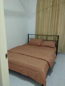 a bed in a bedroom next to a curtain at Homestay Berkat D'sawah Tasek Berangan Pasir Mas in Pasir Mas