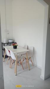 una mesa blanca y sillas en una habitación en Homestay Berkat D'sawah Tasek Berangan Pasir Mas, en Pasir Mas