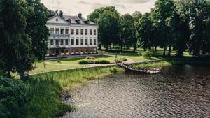 a large white building next to a body of water at Gysinge Herrgård in Österfärnebo
