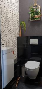 een zwart-witte badkamer met een toilet en een wastafel bij City Centre Apartment in Rēzekne
