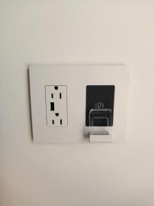 a white lightswitch with a socket on a wall at The Dacha. Cumberland vacation in Cumberland