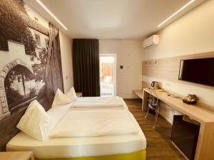 een hotelkamer met twee bedden en een flatscreen-tv bij Casa da Carmen Boutique & Private Spa in Mezzolombardo