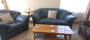 a living room with two couches and a coffee table at Alpha Self-Catering in Sutherland