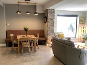 a dining room and living room with a table and chairs at Roundstone Harbour lights Roundstoneselfcatering in Roundstone