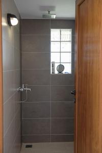 baño con ducha y puerta de cristal en Villa Ilyos, en Ierissos