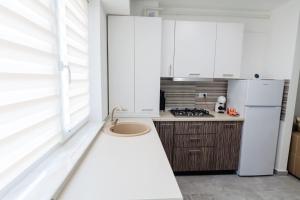 a kitchen with white cabinets and a white refrigerator at Home sweet home 2 in Bacău