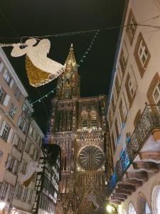um grande edifício com uma torre de relógio à noite em Face à la cathédrale em Estrasburgo