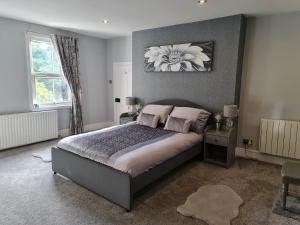 a bedroom with a bed with a flower painting on the wall at Rainworth Lodge in Nottingham