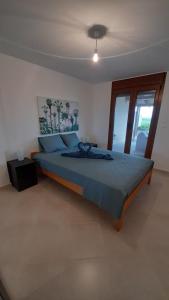 1 dormitorio con 1 cama con edredón azul en Villa Ilyos, en Ierissos