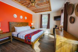 a bedroom with orange walls and a bed and a ceiling at La Posada in Milford