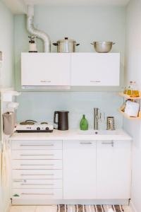 una cocina blanca con armarios blancos y fregadero en Le Vert, en Komotiní