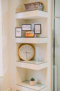 un estante con reloj en una habitación en Le Vert, en Komotiní