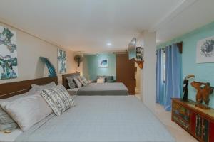 1 dormitorio con 2 camas y TV en la pared en Oasis Diverse Adult Retreat, en Quepos
