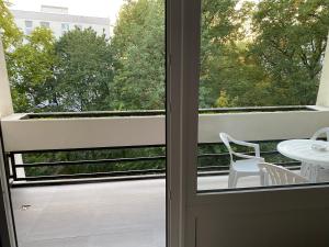 Otwarte drzwi na balkon ze stołem i krzesłami w obiekcie Apartment Hannover Messe w Hanowerze